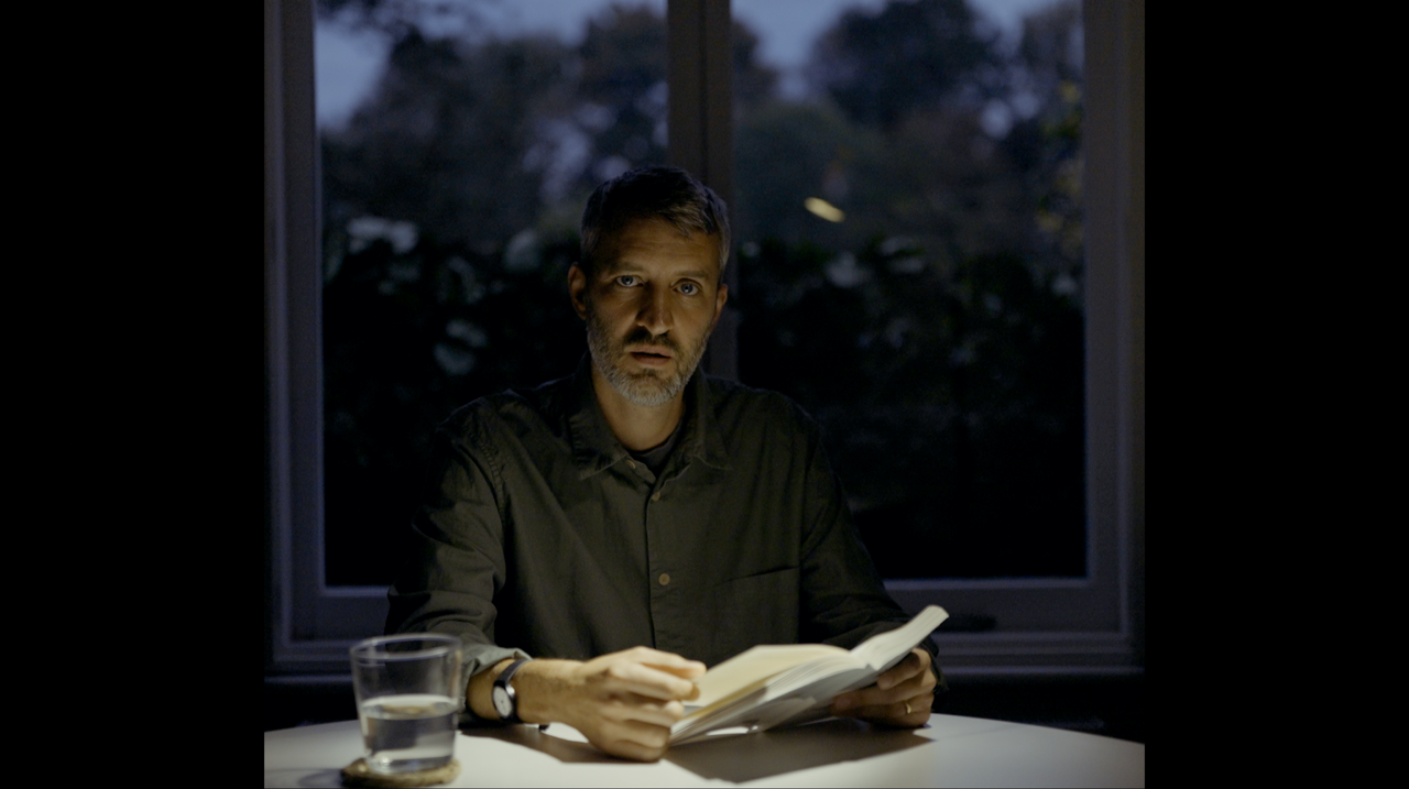 Caleb Klaces reading at a table